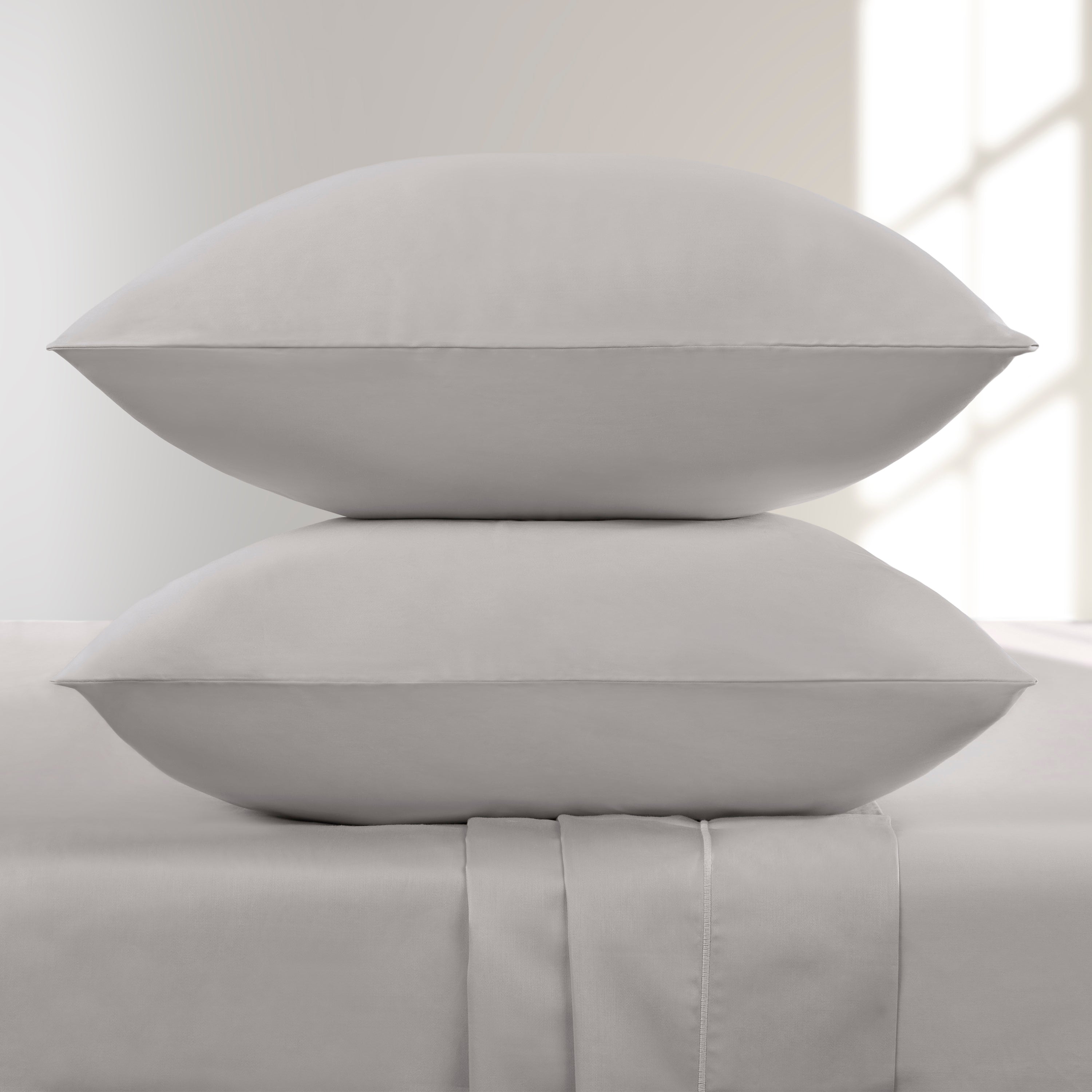Two Lunar Rock pillows stacked on a bed with a neutral background