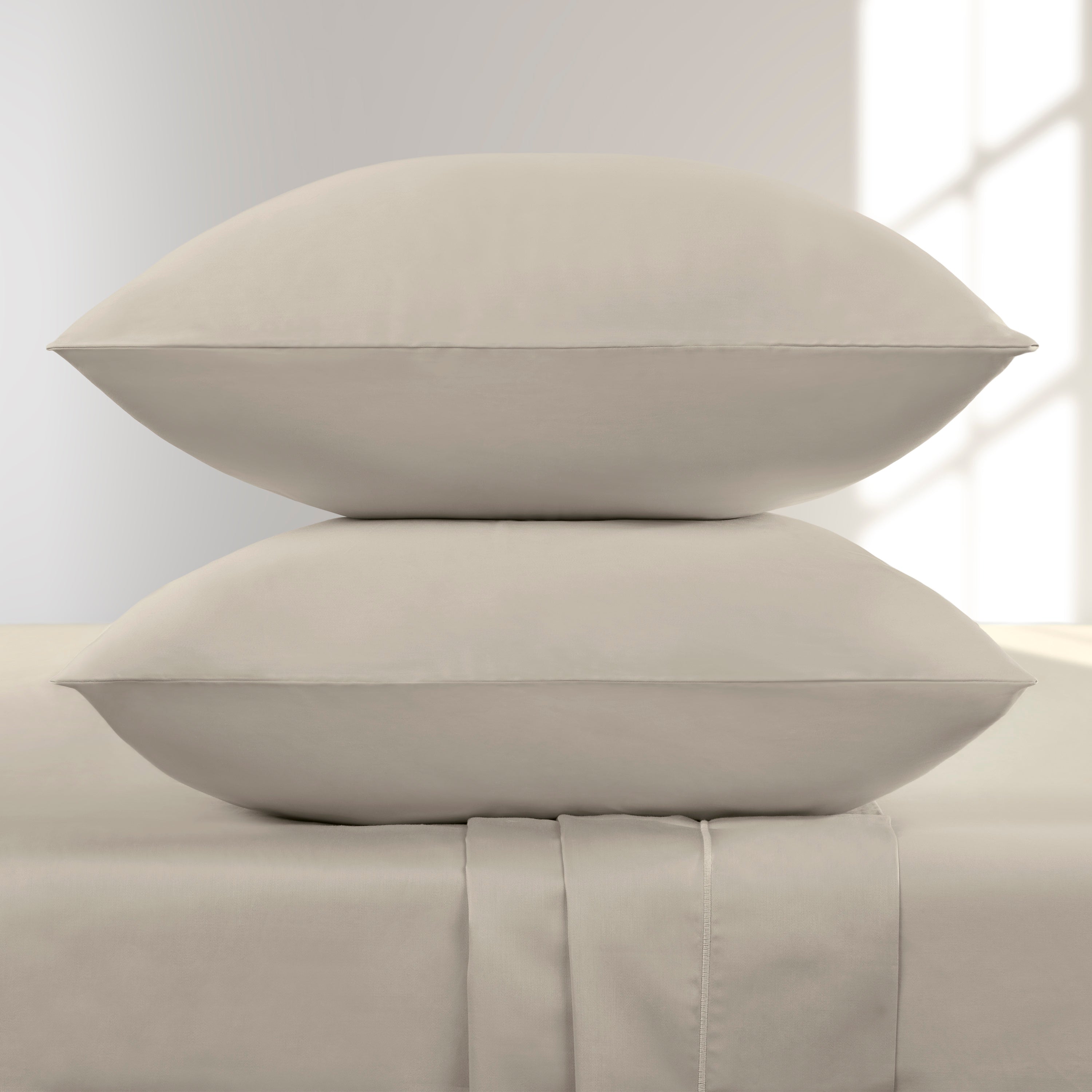 Two Pumice Stone pillows stacked on a matching Pumice bed sheet against a light gray background.
