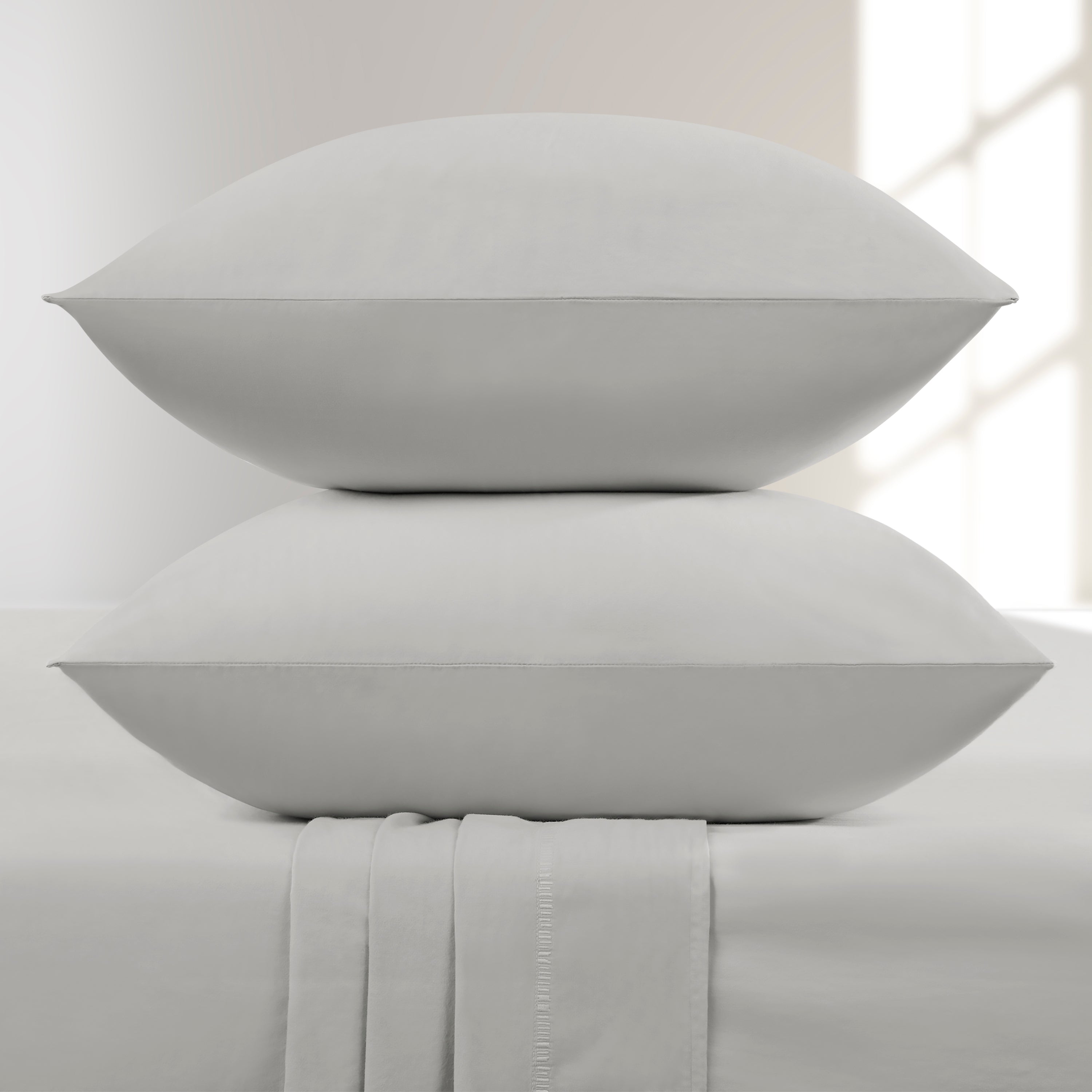 Two Lunar Rock pillows stacked on a bed with a neutral background