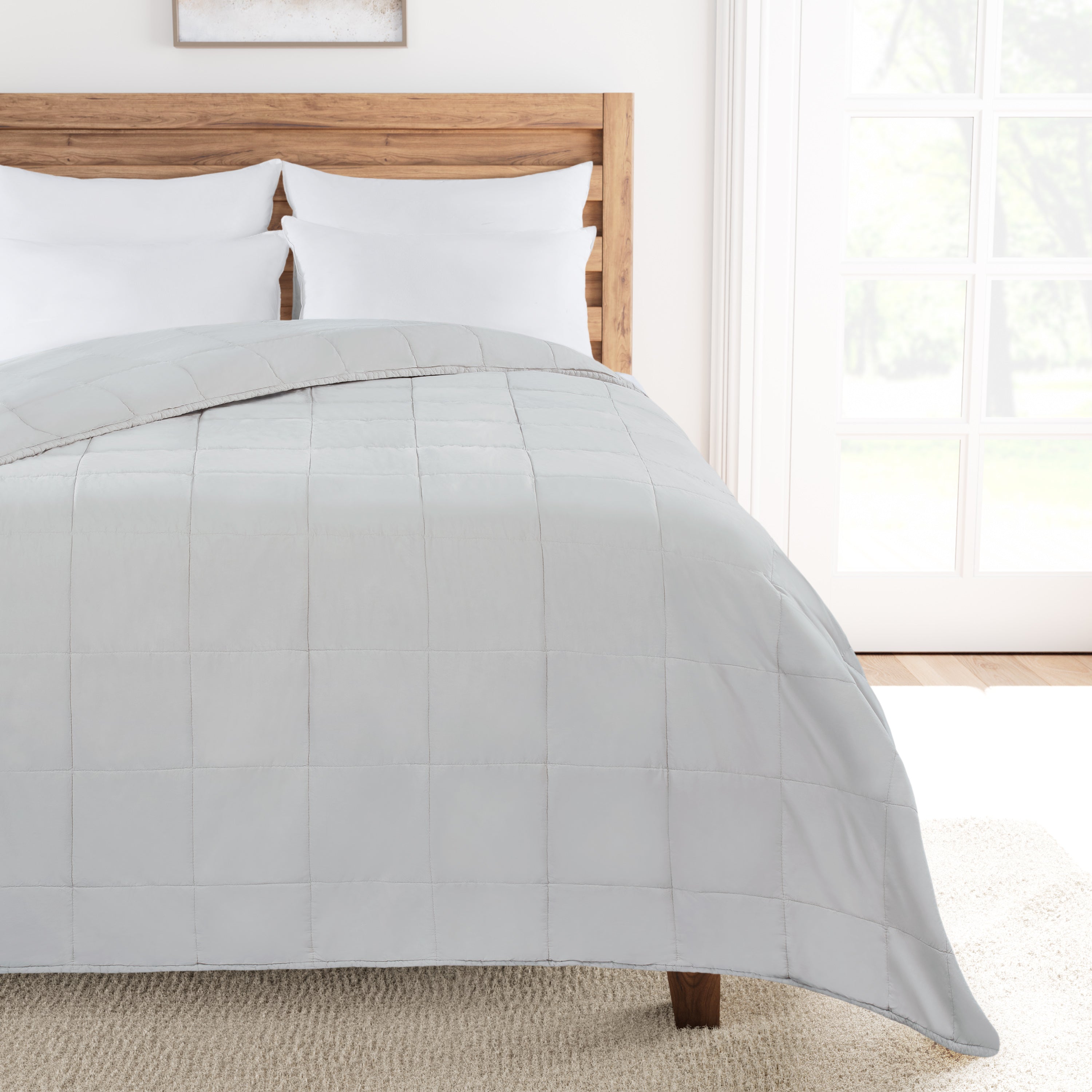 Pumice Stone comforter on a bed in a bright bedroom with wooden headboard