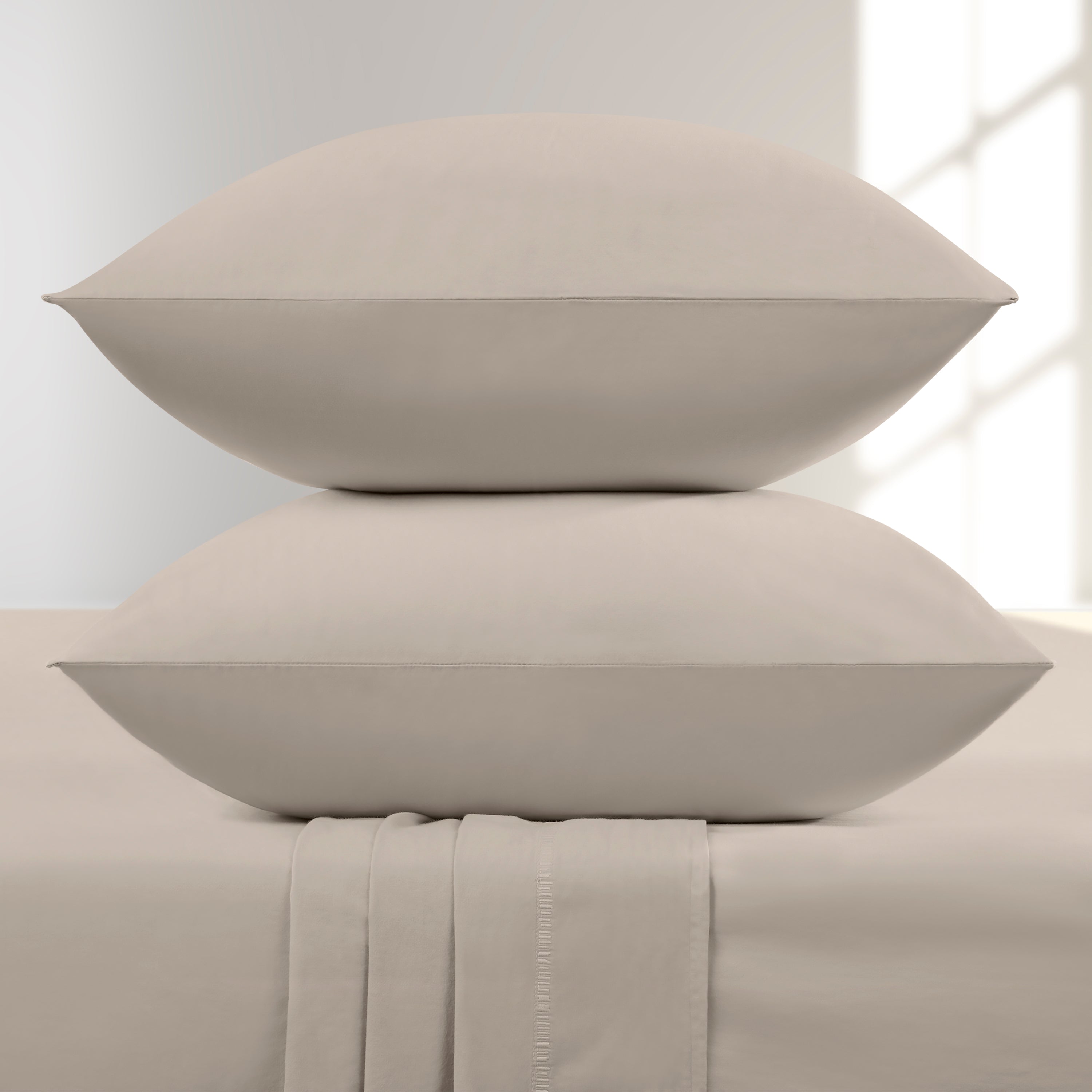 Two Pumice pillows stacked on a bed with a neutral background
