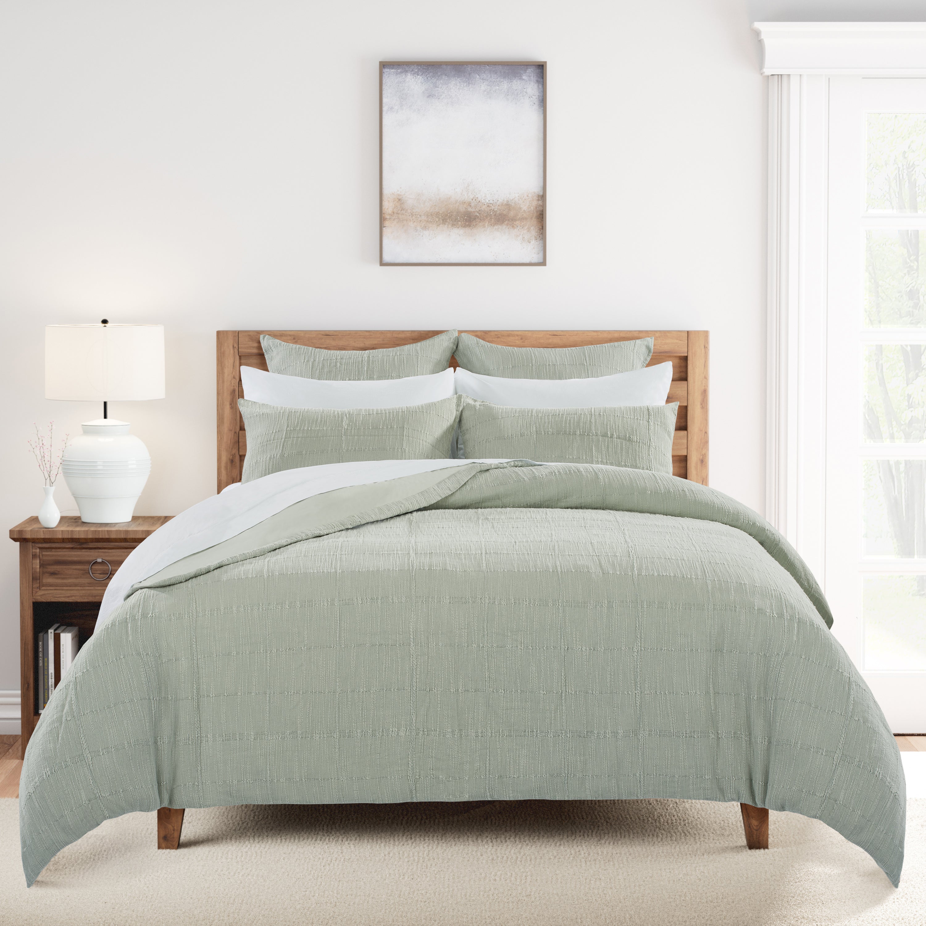 Bedroom with a wooden bed frame, oystershell bedding, and a lamp on a nightstand.