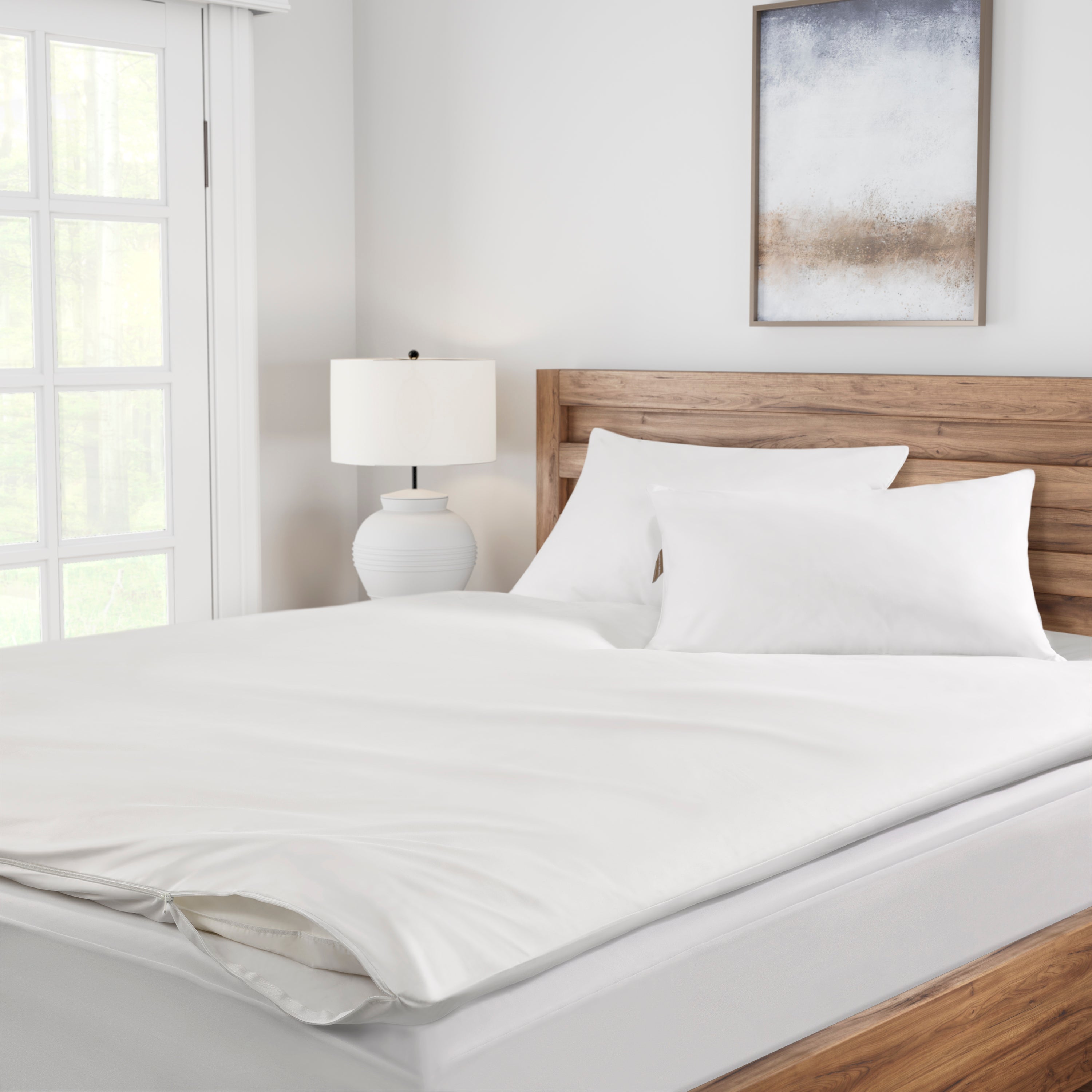 Bedroom with a neatly made bed featuring white bedding and pillows.