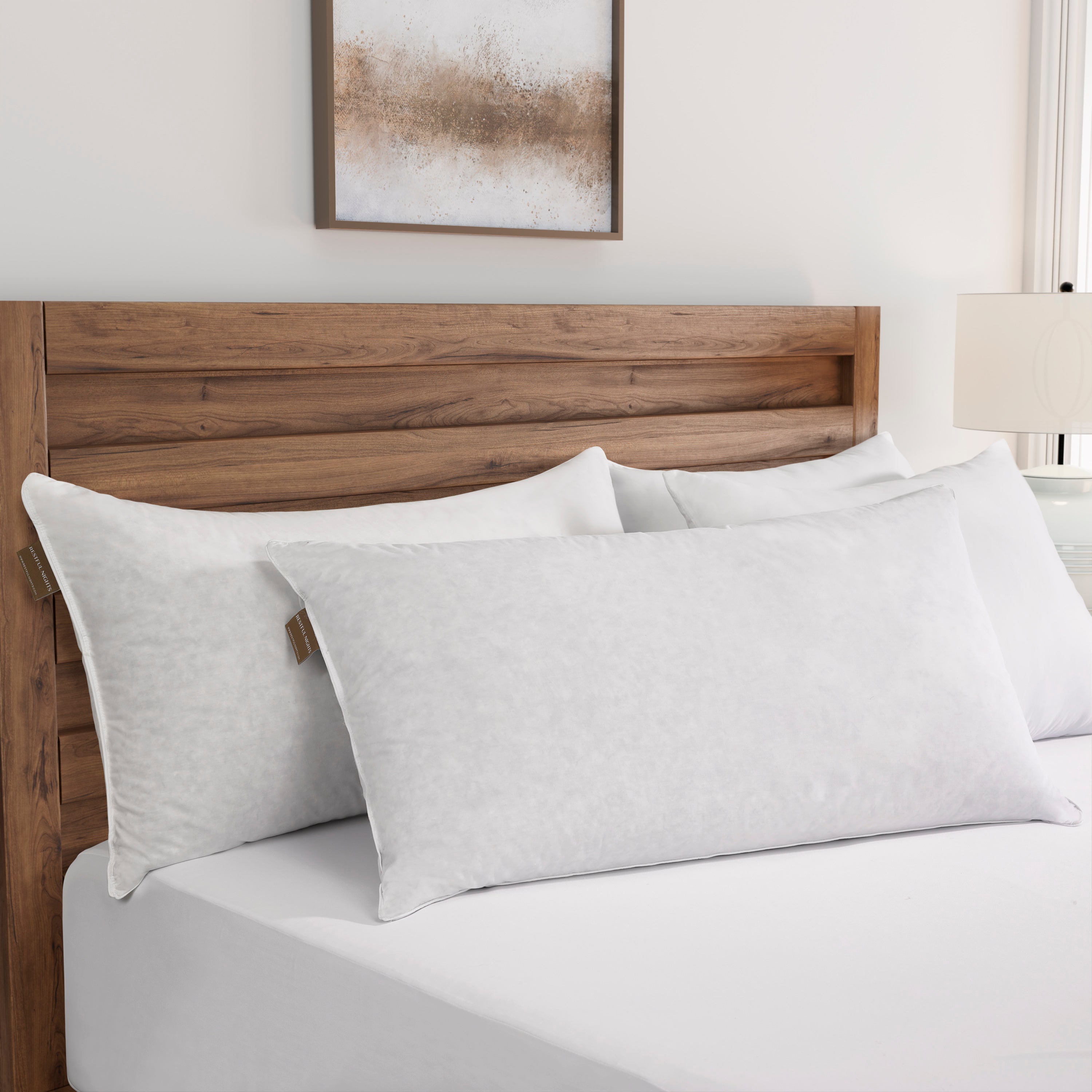 Gray pillows on a bed with a wooden headboard