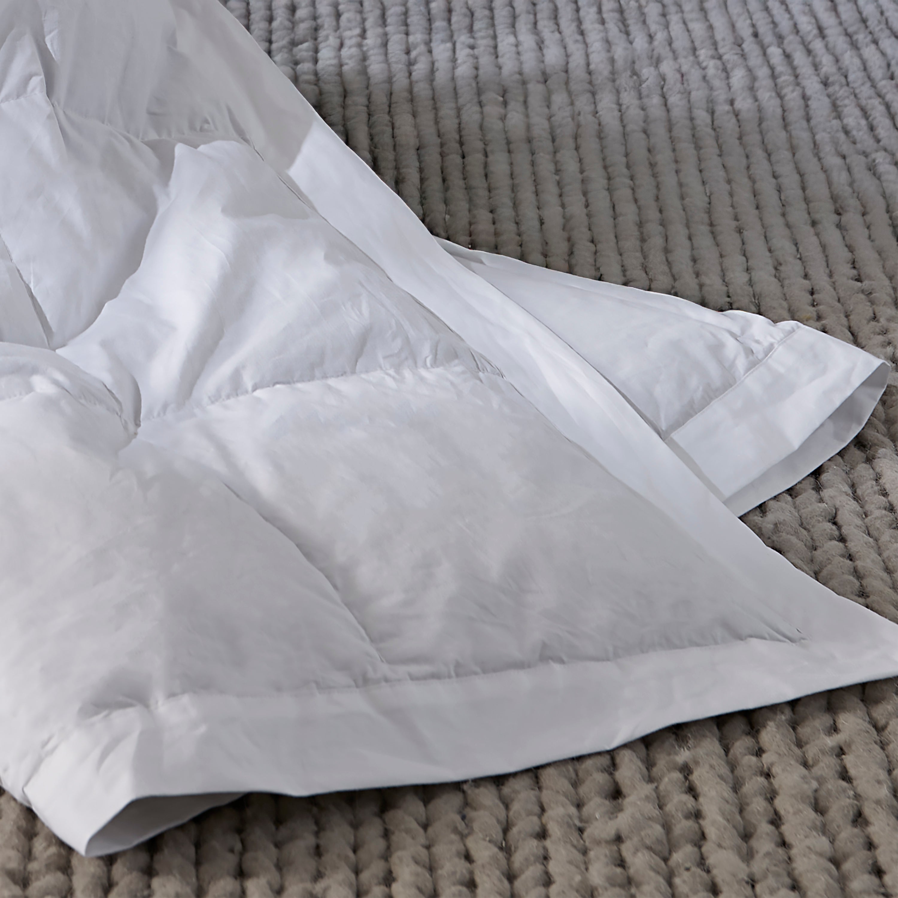 White comforter on a textured gray surface