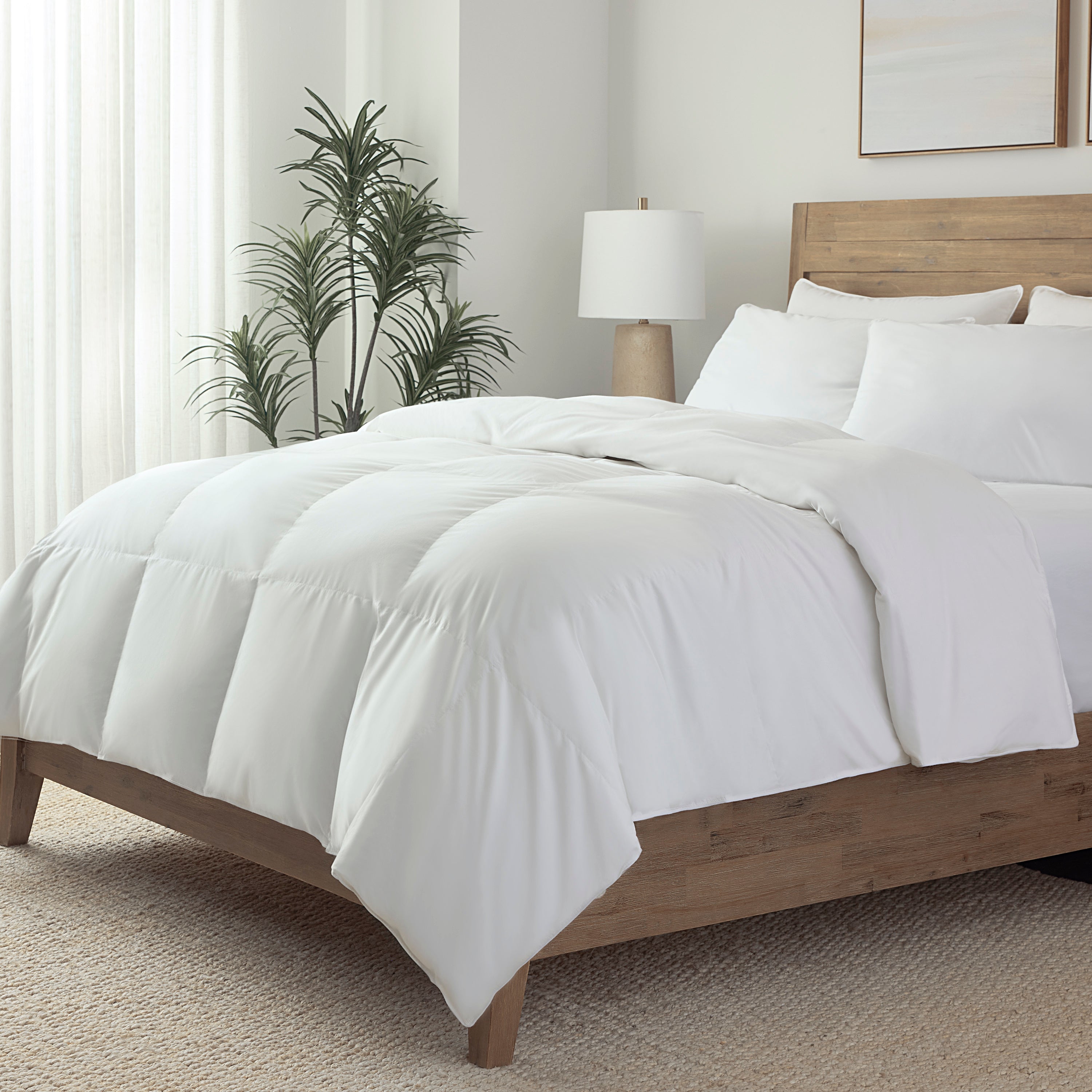 Bedroom with a neatly made bed featuring white bedding and pillows.