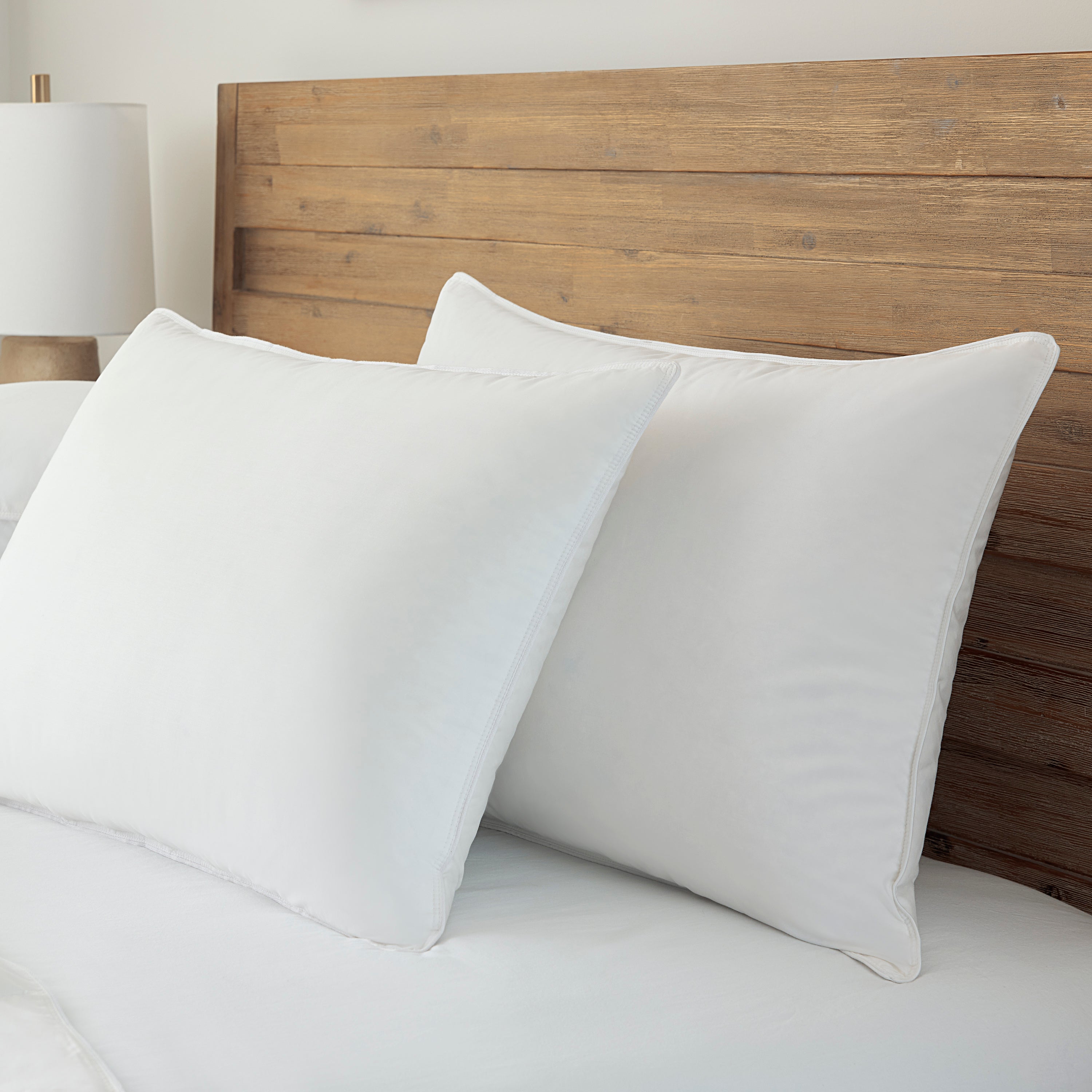 White pillows on a bed with a wooden headboard