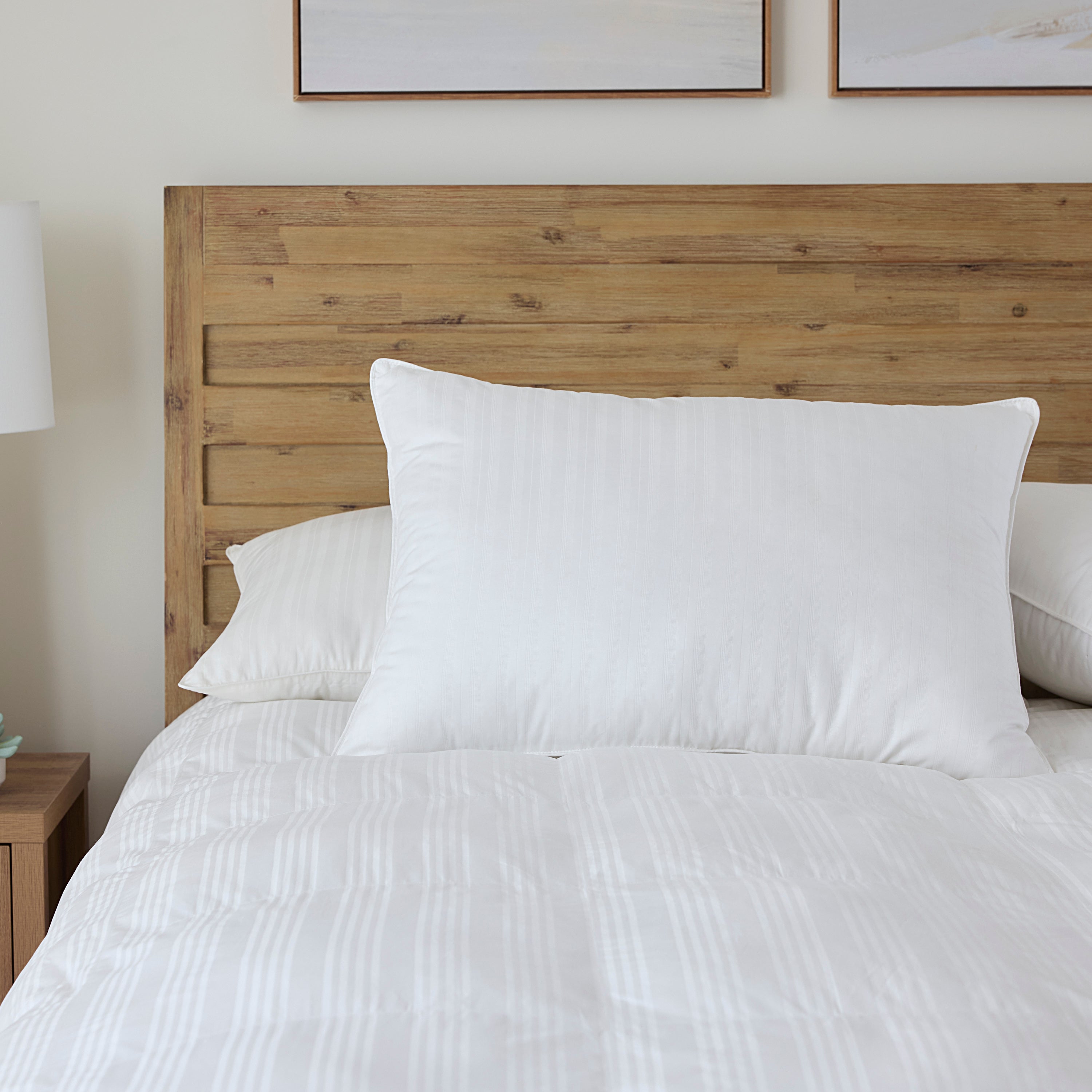 Bed with wooden headboard and white bedding in a bedroom setting