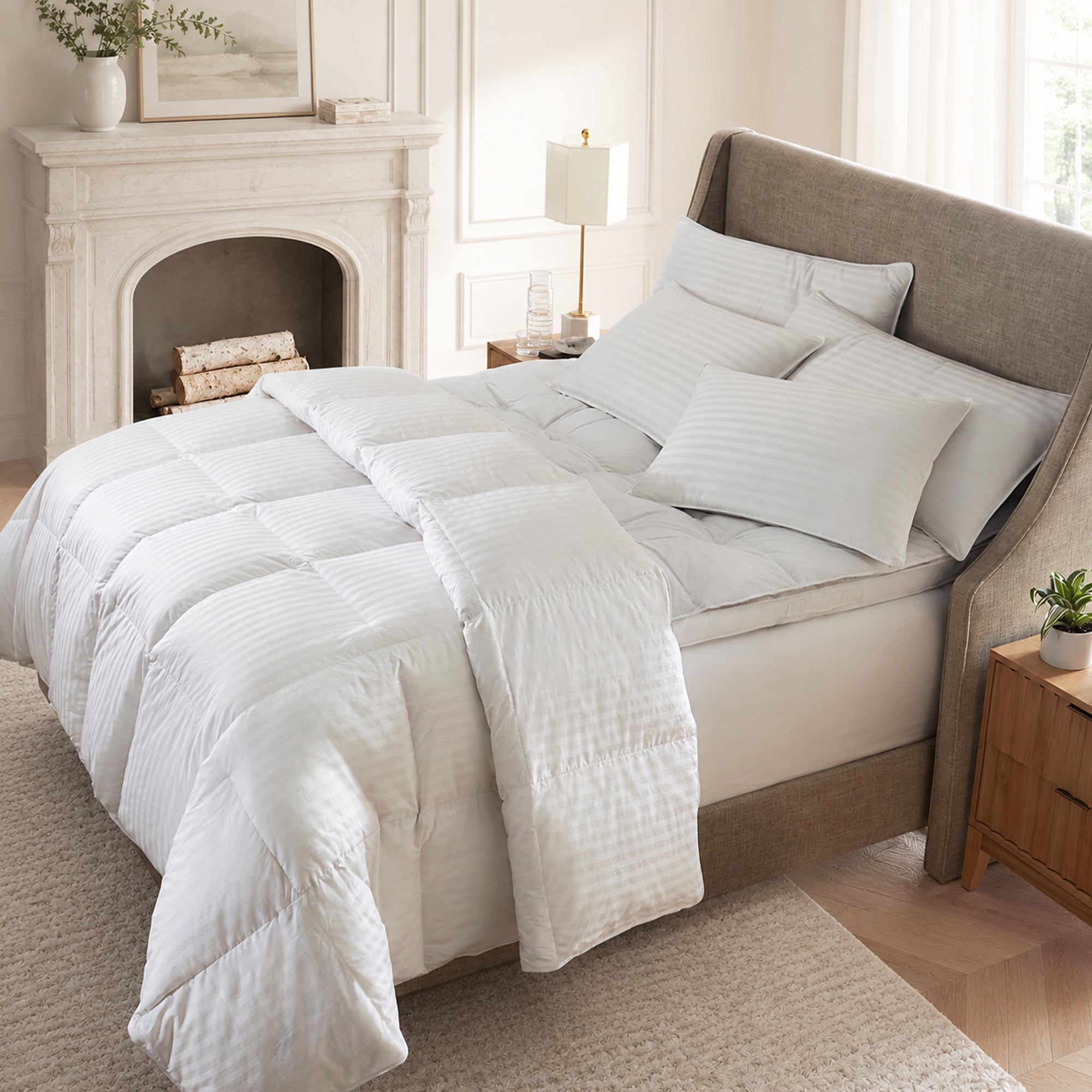 Bedroom with a neatly made bed featuring white bedding, a fireplace, and wooden nightstands.